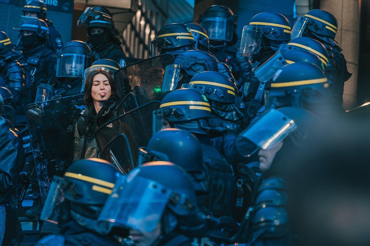 Manifestante diante de uma linha de polícia de choque